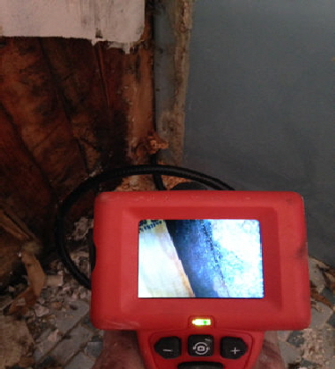 picture of dave inspecting inside the wall with a borescope looking for water damage330x440